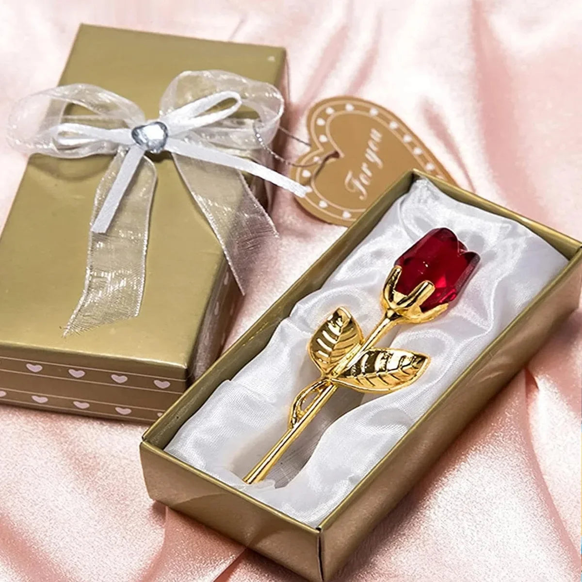 Eine goldene Box mit einer Glaskristall-Rosen-Kunstblumen-Dekoration in einer Samtbox.