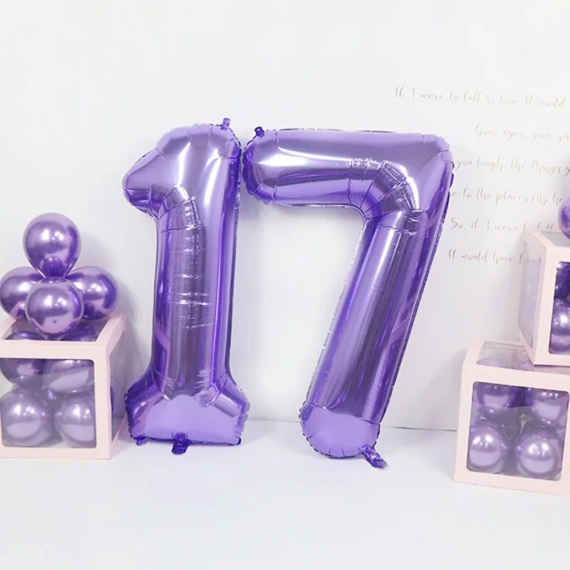 A purple foil number balloon shaped like the number 17 stands next to small boxes filled with purple balloons.