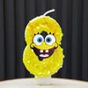 A bright yellow sponge cake shaped like SpongeBob character with large eyes and a wide smile, set on a white base.