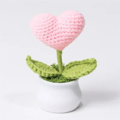 Hand woven pink heart flower in a green leaf potted in a white ceramic container