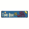 A blue metal sign with the text TIME HERE IS WELL WASTED carved into it, featuring a star and a slice of yellow fruit.