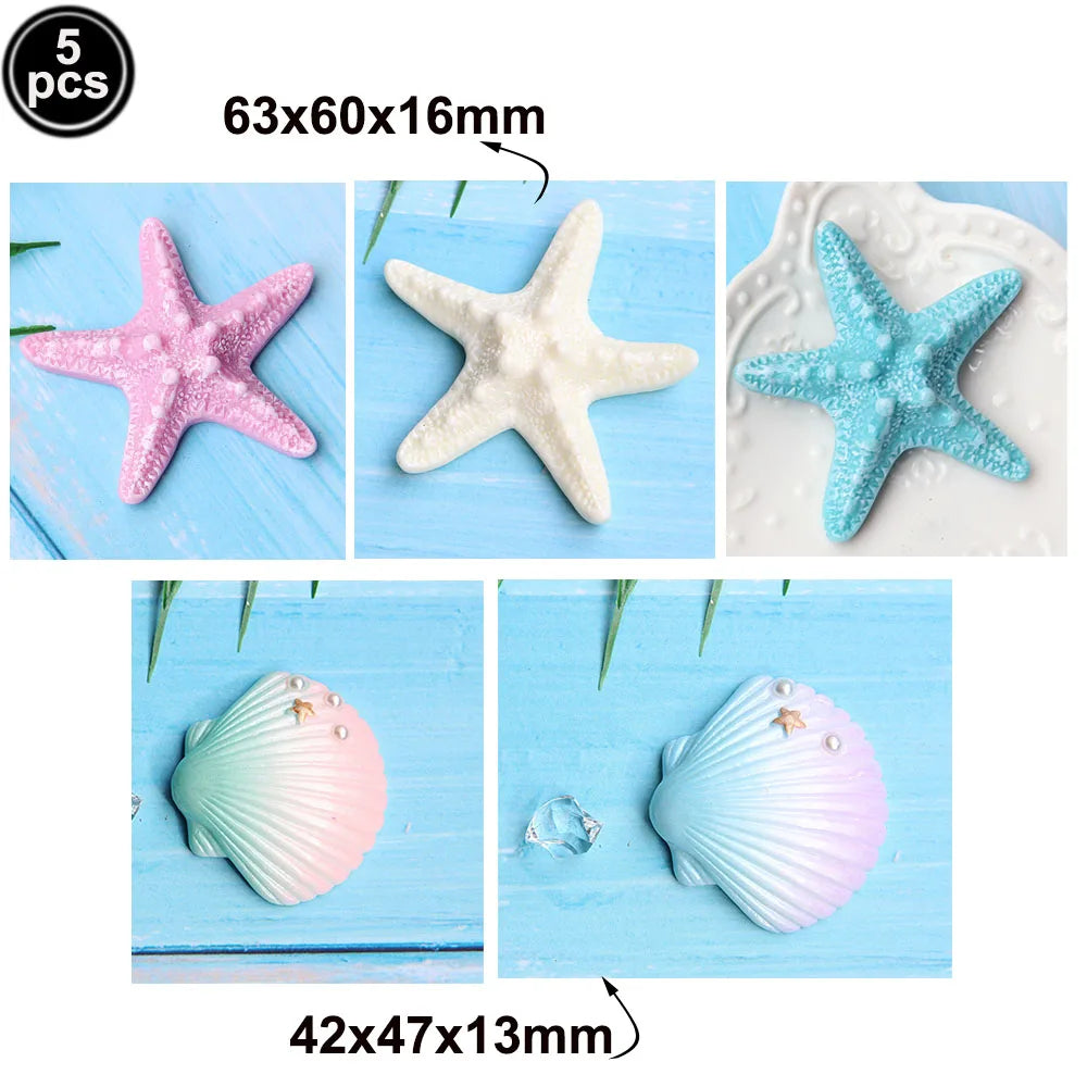 Set of five ocean animal cake toppers including a pink starfish, white starfish, blue starfish, and two seashells.