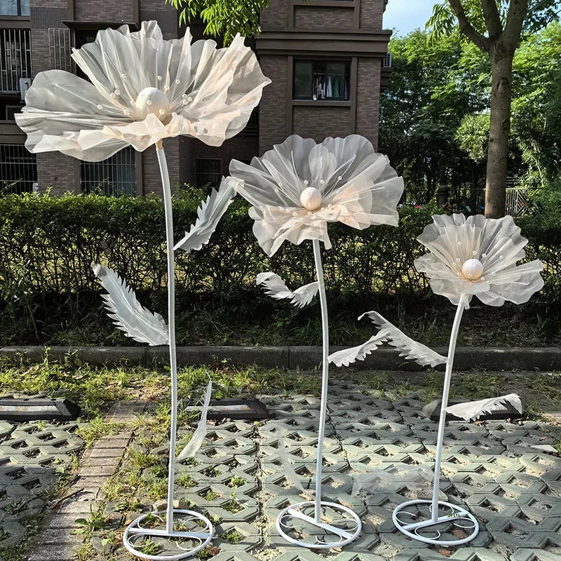 Three large white velvet mesh flowers on metal stands for wedding decoration