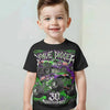 A young boy wearing a black t-shirt featuring a full graphic print of the Monster Jam Grave Digger logo and text.