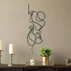 Minimalist abstract face metal wall art featuring a line drawing of a woman's profile on a beige wall.