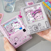 A hand holds a pink photo card album binder featuring cute cat characters and various photo cards.
