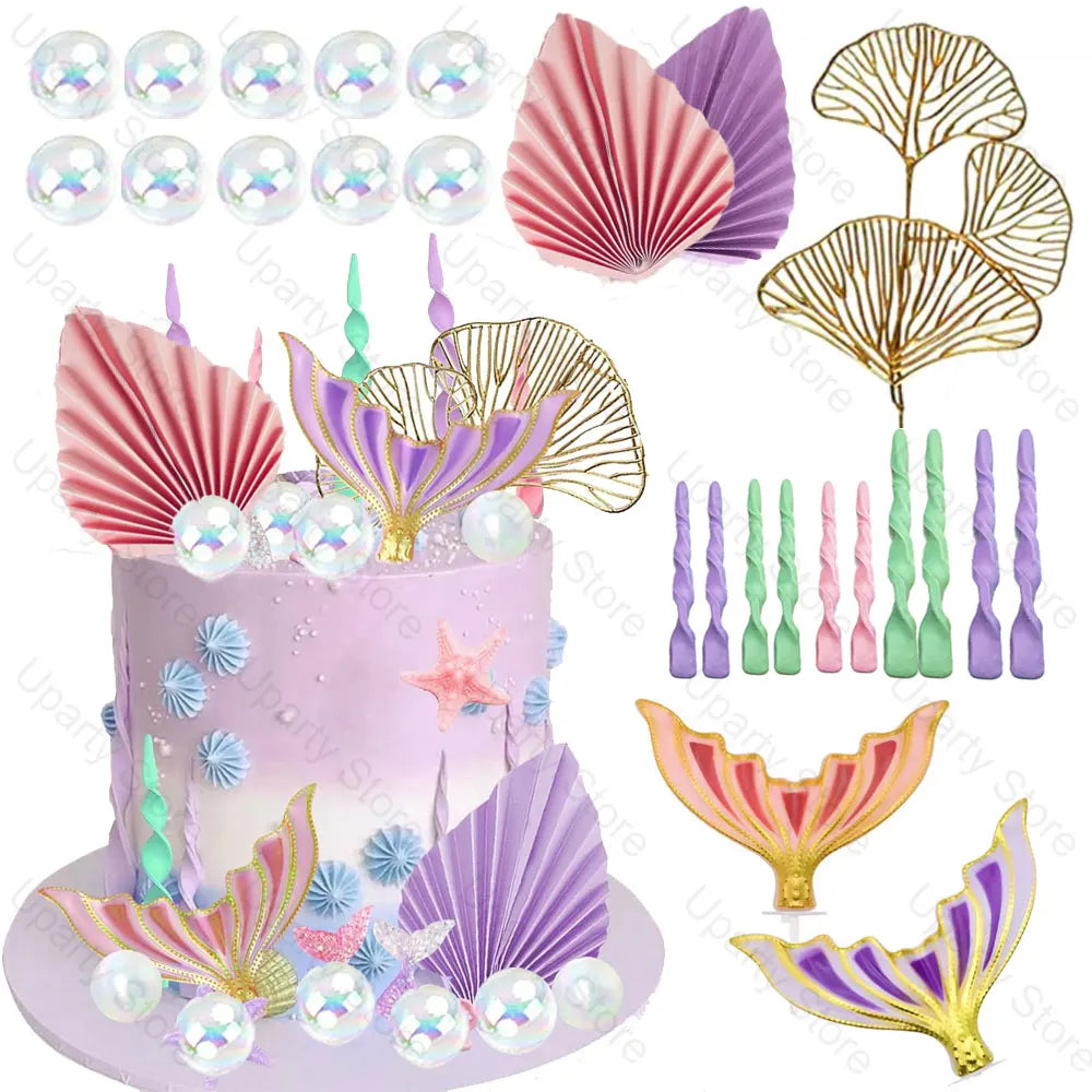 A set of mermaid cake toppers featuring pink and purple seashell and fish-like tail decorations.