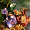 A festive arrangement of Christmas kraft paper gift bags tied with twine and decorated with seal stickers.