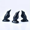 Three handcrafted black obsidian crow statues displayed on a white surface.