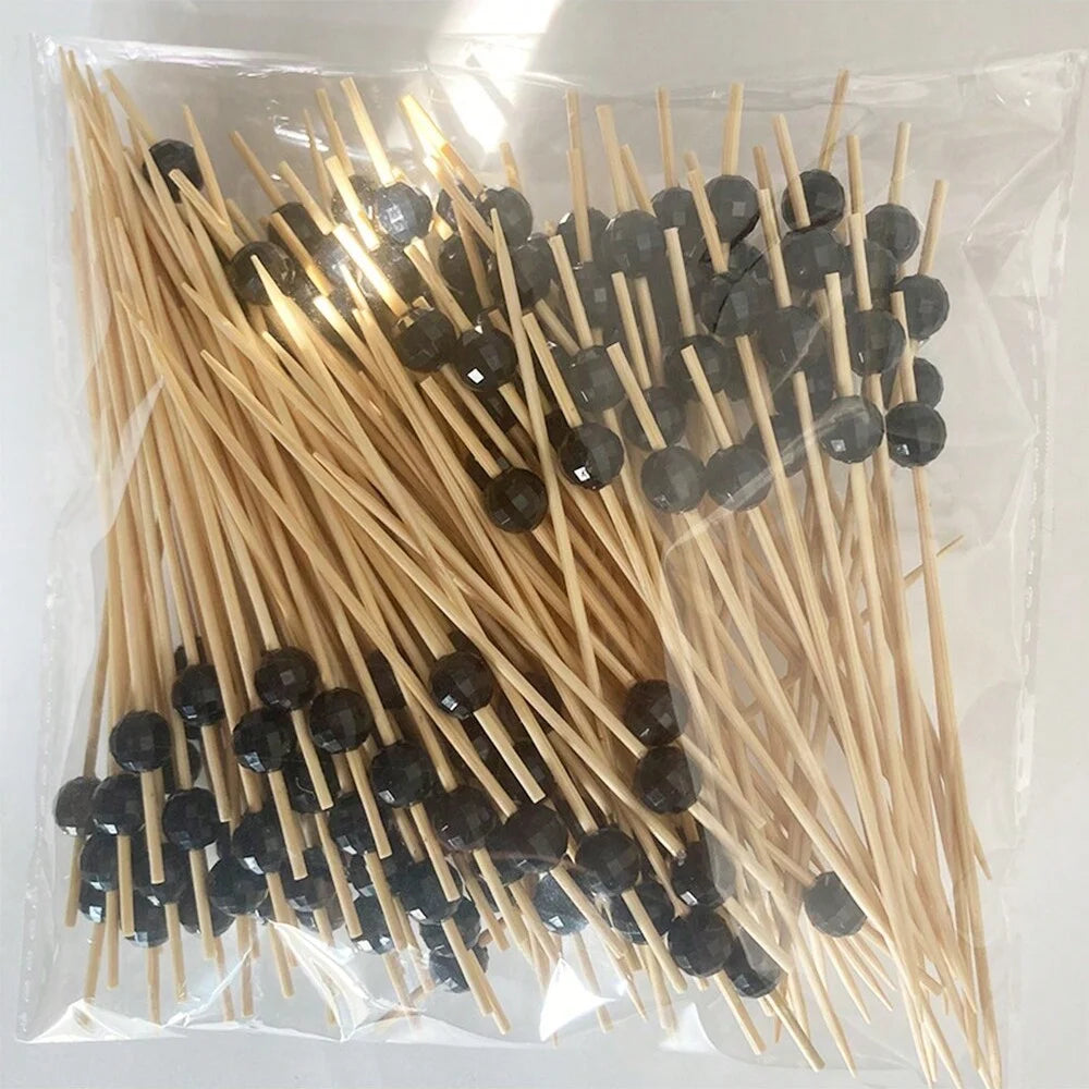 A clear plastic bag filled with numerous bamboo fruit skewers for parties and cocktails.