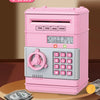 A pink password saving piggy bank with a numeric keypad and slots for currency is displayed on a wooden surface.