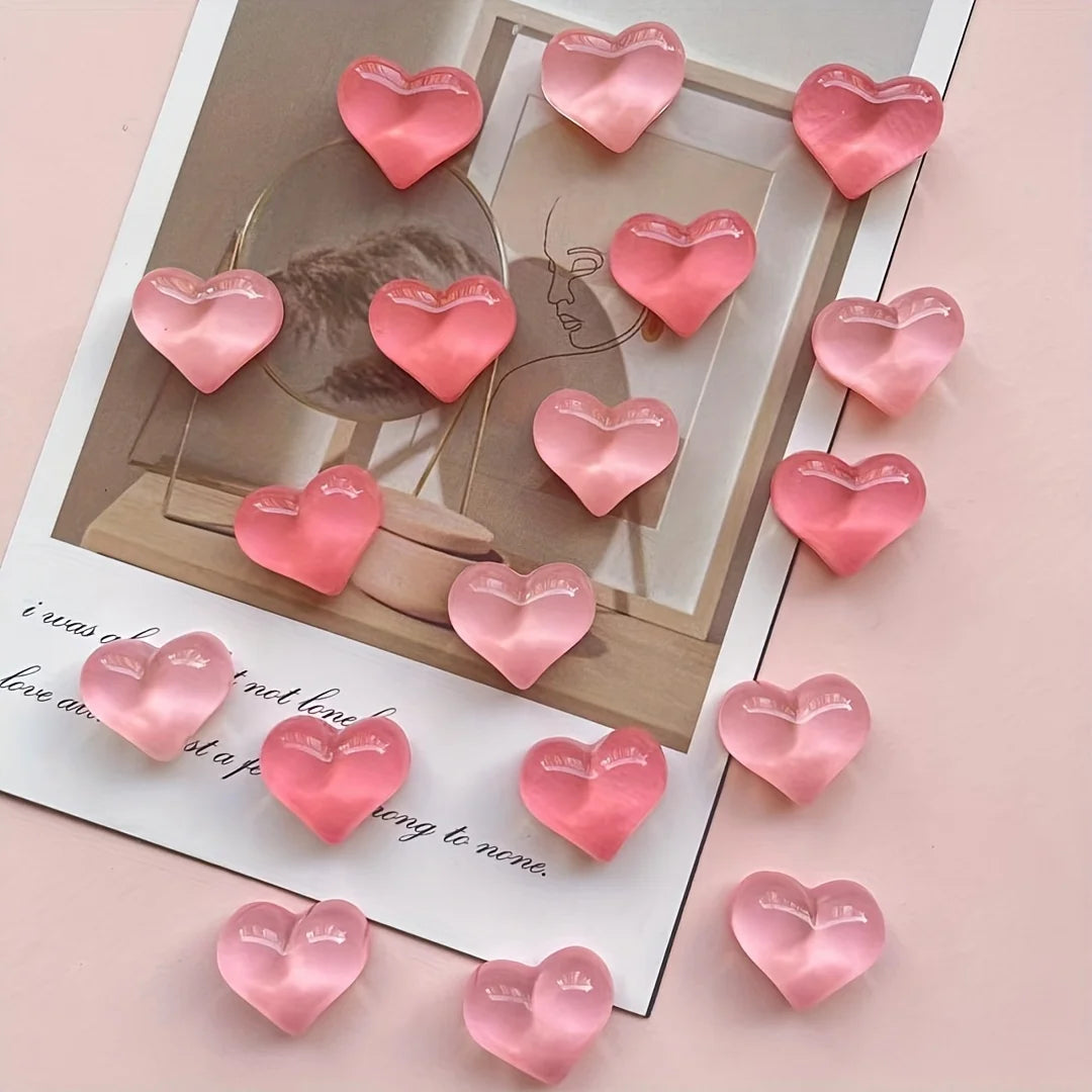 A set of ten heart-shaped pink resin magnets arranged on a white card against a light pink background.