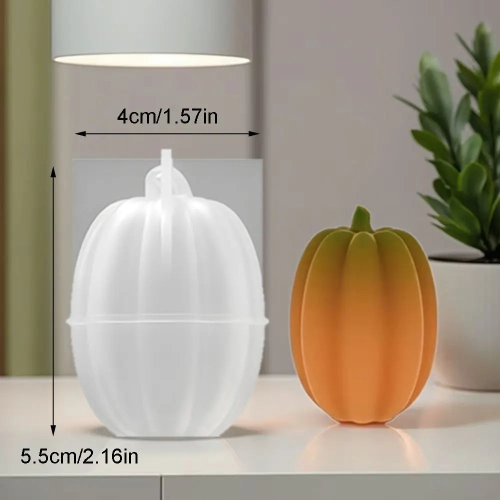 White silicone pumpkin mold with measurements shown next to a real orange pumpkin.