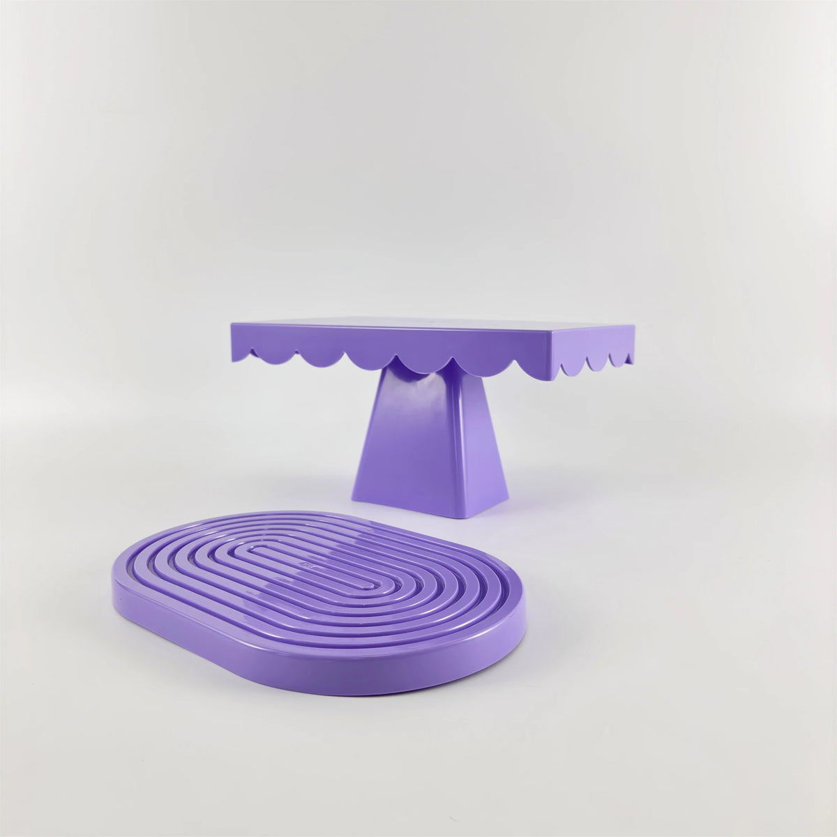 A purple cupcake stand with a scalloped top and a round purple stand for party decor.