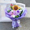 A purple handmade crochet flower bouquet featuring a large yellow sunflower and various purple and white flowers.