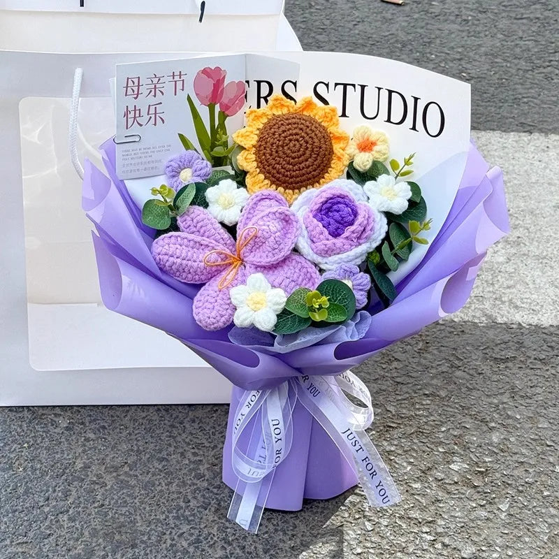A purple handmade crochet flower bouquet featuring a large yellow sunflower and various purple and white flowers.