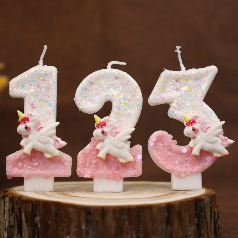 Tres velas numéricas rosas y blancas brillantes con los números '123' mostradas en una rodaja de madera.