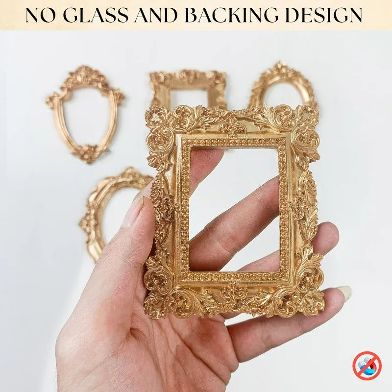 A hand holds a gold-colored vintage resin picture frame with intricate floral detailing.