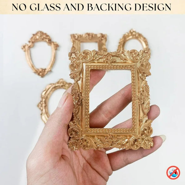 A hand holds a gold-colored vintage resin picture frame with intricate floral detailing.