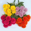 A bouquet of artificial hydrangea and camellia flowers in shades of yellow, pink, and orange.