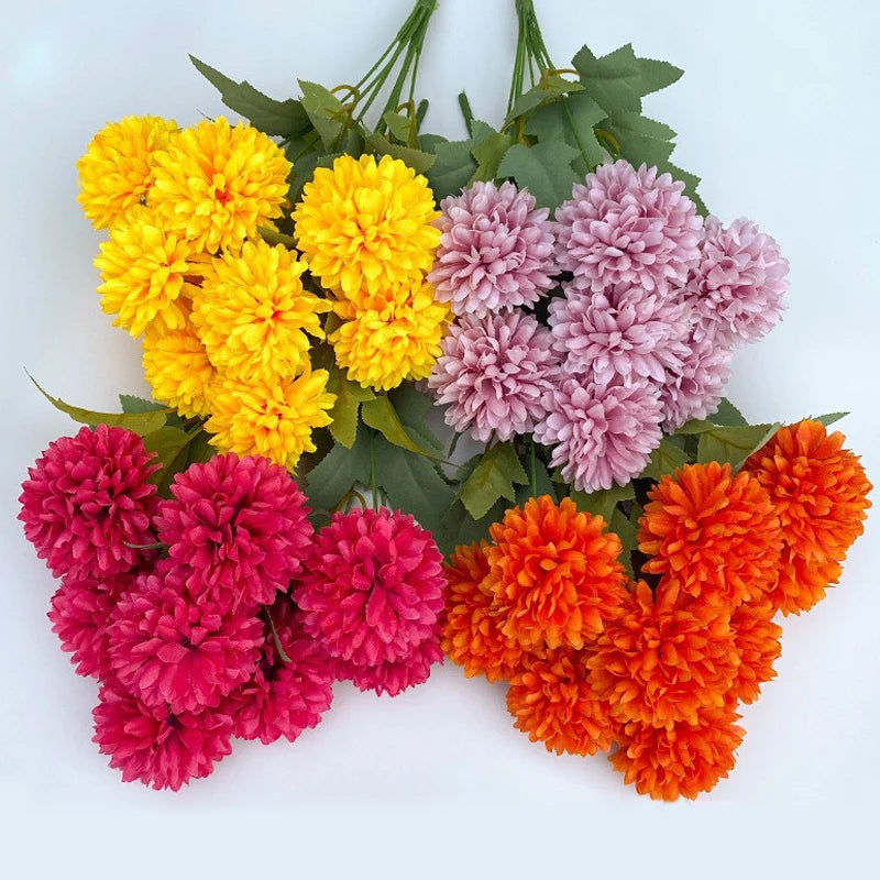 A bouquet of artificial hydrangea and camellia flowers in shades of yellow, pink, and orange.