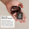A hand holds a dark brown cord necklace set with Catholic symbols and a small card, illustrating sharing spiritual blessings.