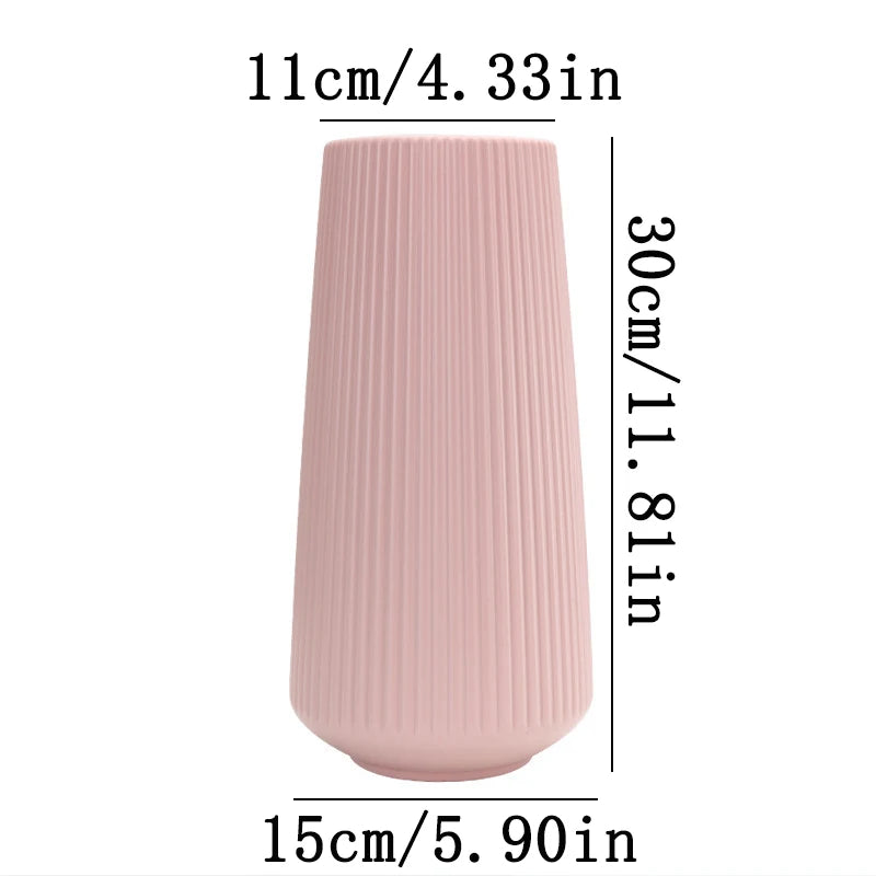 A tall, cylindrical pink ceramic vase with vertical ribbed texture.