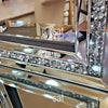 A silver crystal beveled wall mirror with a reflective frame and dark trim.