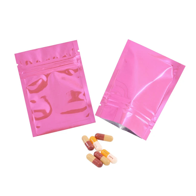 Pink foil zip bags containing several pills or capsules.