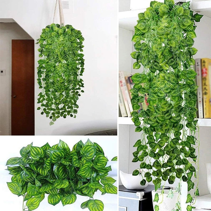 A lush green artificial ivy vine garland hanging on a white wall, shown alongside a potted plant.