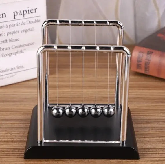 A silver Newton's cradle with glass balls on a black base.