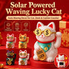 A white cat figurine with gold accents and sunglasses is shown next to other lucky cat ornaments on a red surface.