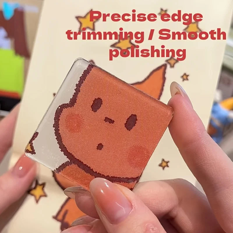 A hand holds a square, translucent orange-brown fridge magnet with precise edge trimming and smoothing.