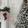 A Christmas tree decorated with gold ornaments and a hanging crystal sunshine catcher set.