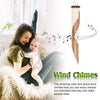 A mother holds a baby while a wind chime hangs, illustrating the clear and graceful melodies of the wind chimes.