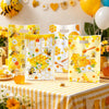 Yellow and white honeycomb patterned gift bags with handles filled with honey and flowers