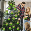 A woman decorating a Christmas tree with green faux fur ornaments featuring bows.