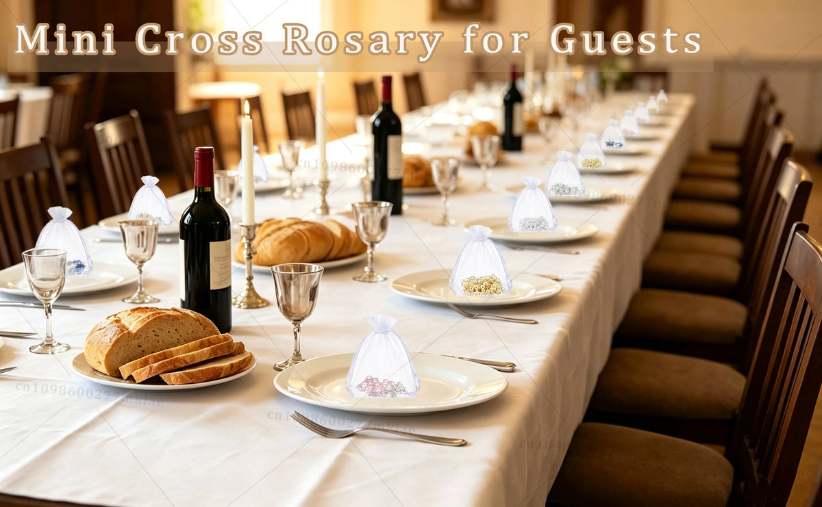 A table setting displaying mini cross rosary favors for guests on a white tablecloth.