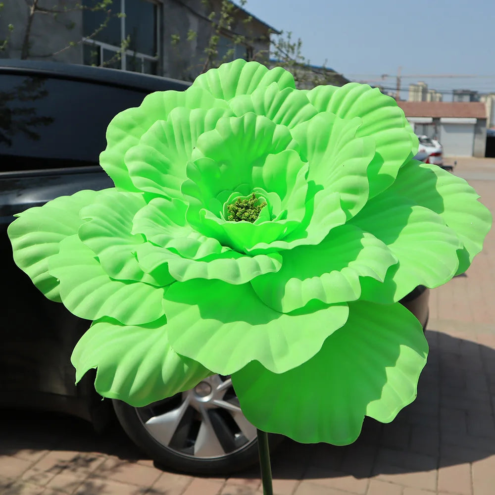 A vibrant lime green artificial peony flower with layered petals displayed outdoors.