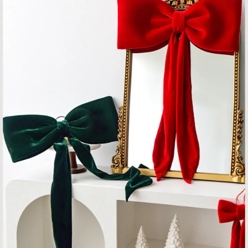 A set of velvet Christmas tree bows in red and green, displayed against a gold-framed mirror.
