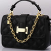A black quilted shoulder bag with gold-tone metal chain hardware and a rectangular pendant.