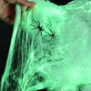 Glow-in-the-dark spider web Halloween decor featuring fake spiders on a translucent green background.
