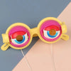 Yellow novelty glasses with pink and blue lenses displayed against a light background.