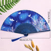 A blue and purple elegant bamboo folding hand fan with a tassel displayed on a light background.