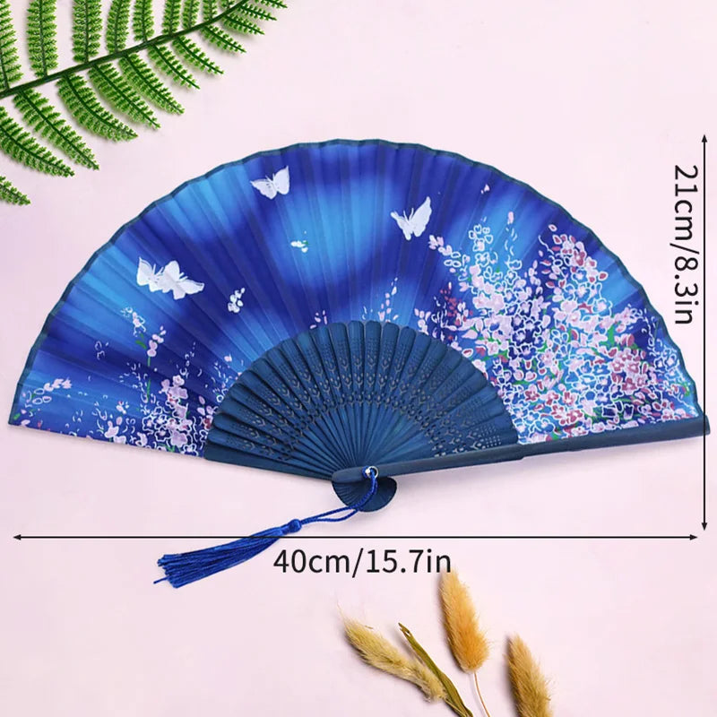 A blue and purple elegant bamboo folding hand fan with a tassel displayed on a light background.