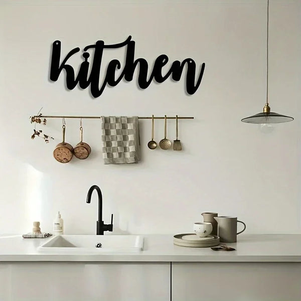 Arte de pared en escritura negra sobre la cocina, encima del grifo y utensilios colgados en un rack