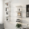 A white five-tier wall-mounted storage shelf displaying various decorative objects and books.
