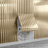 Metallic gold striped peel-and-stick wallpaper installed on a wall.