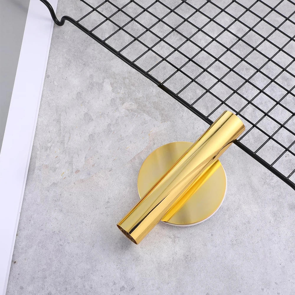 A gold-colored metal flower vase is displayed on a black wire grid against a light gray background.