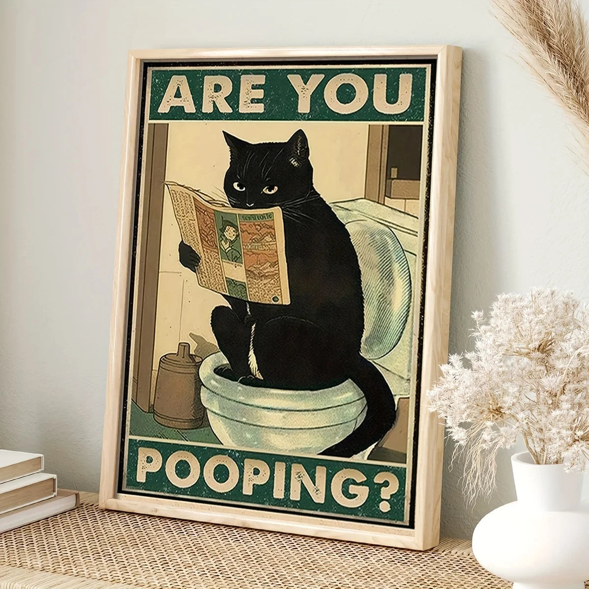 A framed poster featuring a black cat looking surprised with the text Are You Pooping?